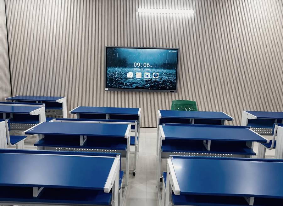 Representative image of a classroom fitted with a smart board and modern desks